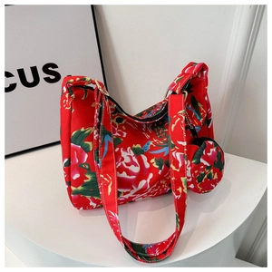 Detailed view of red floral shoulder bag with matching round coin purse on a display stand
