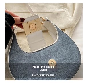 Detail view of denim and leather saddle bag featuring a gold magnetic snap closure