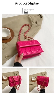 Detail view of pink quilted square bag with gold chain strap and leaf pattern