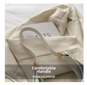 Close-up of cream shoulder bag strap with premium gold hardware and leather texture