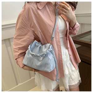 Light blue ruched cloud bag with woven handle and adjustable strap shown on model