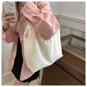 Detail of white lace pleated shoulder bag showing delicate fabric texture and large capacity