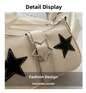 Detail of denim shoulder bag featuring black star patches and silver star metal buckle