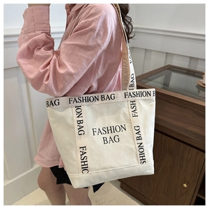 Detail of canvas tote bag showing fashion bag letter printing and wide fabric handles