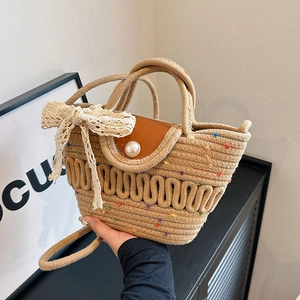 Straw woven tote bag with brown leather lid, large pearl buckle and lace bow accent