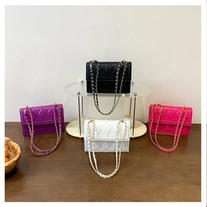 Detailed display of four quilted chain crossbody bags in black, white, purple, and rose red
