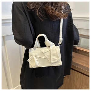 Detail of creative folded fabric texture on a cream canvas crossbody bag shown on a model