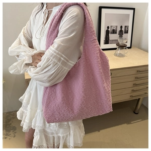 Detailed texture view of a pink popcorn pleated shoulder bag shown in lifestyle setting