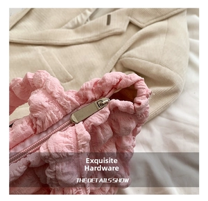 Detail of pink bubble texture fabric with high-quality silver metal zipper on the bag