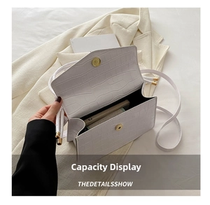 Detailed view of white crocodile pattern leather handbag interior with magnetic closure