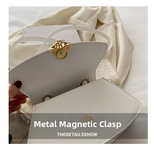Détail du fermoir magnétique doré d'un sac à main moderne en cuir PU blanc