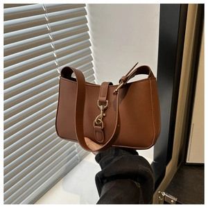 Close-up of retro brown shoulder bag with vintage gold buckle and smooth matte leather texture