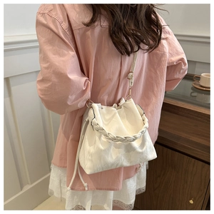Detailed view of white drawstring bucket bag with thick woven handle and soft PU texture