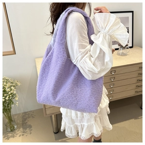 Detail of lavender textured tote bag featuring bubble fabric and integrated wide shoulder strap