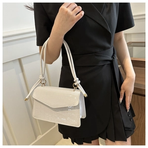 Detail of white crocodile embossed crossbody bag with glossy finish and knot strap