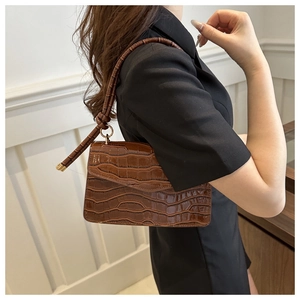 Detail view of dark brown faux leather shoulder bag with glossy crocodile texture