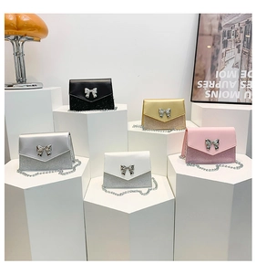 Dettaglio colori borsa a tracolla con fibbia a fiocco metallico e texture lucida