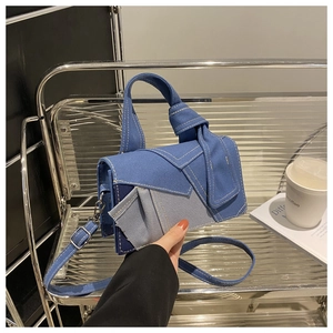 Detail view of the denim patchwork crossbody bag with stylish knotted handle and contrast stitching