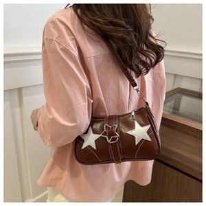 Détail de l'écusson étoile et boucle métallique sur le sac bandoulière en cuir PU brun