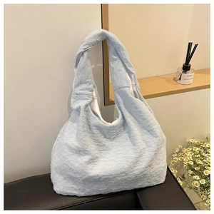 Detail of light blue pleated tote bag showing the 3D textured seersucker fabric finish