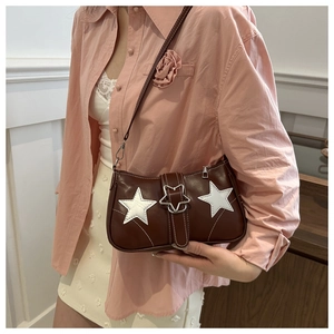Close-up of brown vintage underarm bag featuring white star patches and star metal buckle