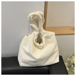 Close-up of beige pleated tote bag featuring textured bubble fabric and soft handle detail