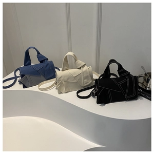 Denim patchwork crossbody bags in blue, white, and black with knotted handles