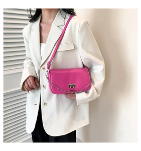 Detail of fuchsia crossbody bag showing silver metal buckle and adjustable strap