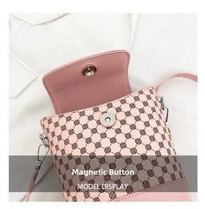 Détail du sac seau en cuir rose montrant le fermoir magnétique et l'imprimé trèfle
