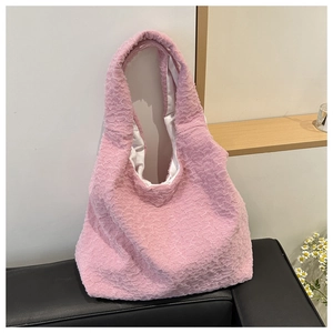 Detailed close-up of light pink tote bag with textured bubble fabric and shoulder strap