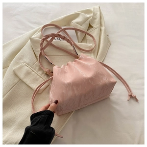 Detail of pink marble pattern bucket bag with woven strap and drawstring closure