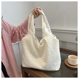 Detail of white pleated tote bag showing soft bubble texture and spacious interior