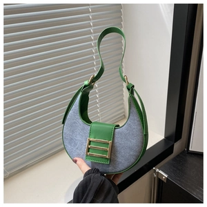 Detailed shot of crescent shoulder bag featuring green leather and gray fabric patchwork