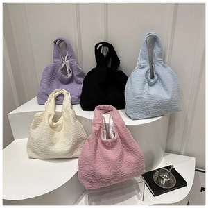 Detailed row of quilted puffer tote bags in purple, blue, white, pink and black