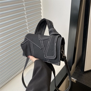 Chic black canvas crossbody handbag featuring contrast white stitching and top handle