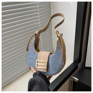 Detail of blue denim crescent bag with khaki leather trim and gold buckle closure
