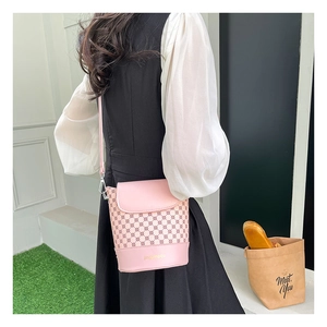 Détail du sac seau rose imprimé vintage avec bandoulière et motifs géométriques