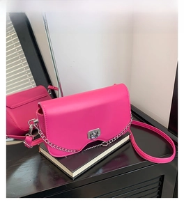 Close-up of rose red crossbody bag with silver twist lock and metal chain strap