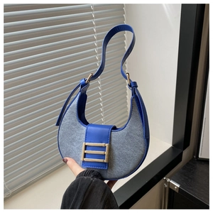 Detail of blue and grey patchwork crescent bag with golden metal hardware buckle