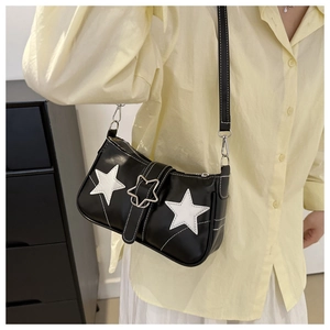 Détail du sac à bandoulière noir avec patchs étoiles blancs et boucle métallique