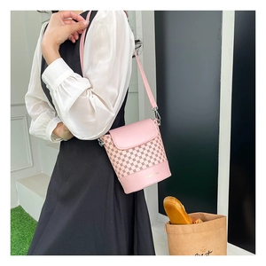 Détail du sac seau rose avec imprimé géométrique, base en cuir et attache métallique