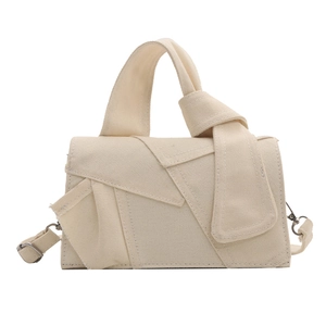 Minimalist beige canvas handbag with unique folded layering and knotted strap design