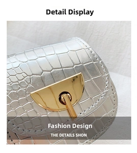 Detail of silver crocodile pattern handbag with golden semi-circle metal buckle and stitching