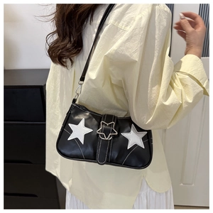 Close-up of black shoulder bag with white star patches and silver star buckle on model