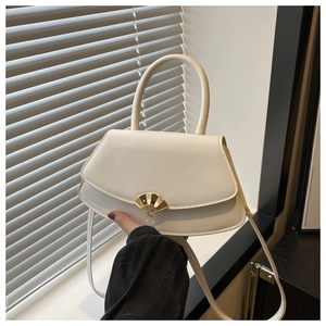 Détail d'un sac en cuir blanc crème avec un fermoir doré en éventail et poignée