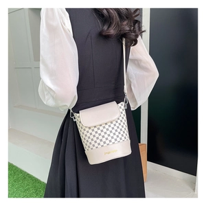 Détails d'un sac seau vintage avec imprimé monogramme classique et bordures en similicuir