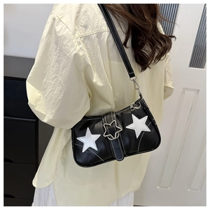 Detail of black PU underarm bag featuring white star patches and silver metal buckle