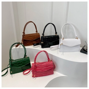 Detail of colorful crocodile embossed leather bags with golden hardware and knot handles