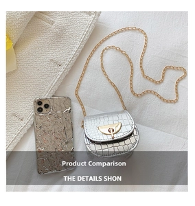Detail of silver crocodile pattern saddle bag with gold chain and metal buckle closure