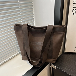 Brown canvas tote bag with fashion bag print on minimalist indoor window background